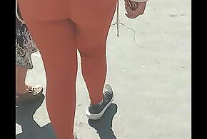 Culona mexicana en leggins naranjas en la calle